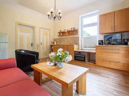 Der Wohnbereich mit Couchgarnitur und Küchenzeile