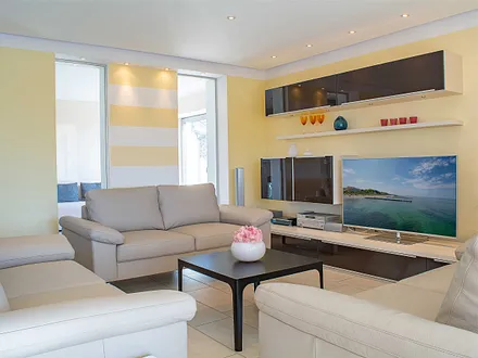 Das gemütliche Wohnzimmer mit Sitzecke und Flachbild-TV