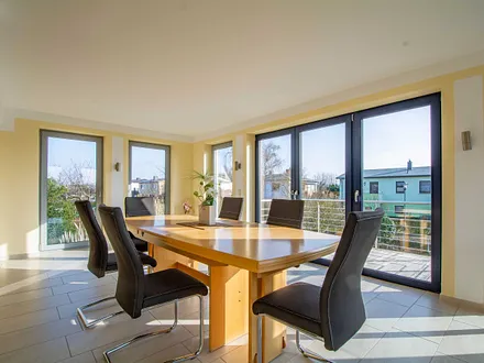 Der große Esstisch im Wintergarten mit Zugang zur Terrasse