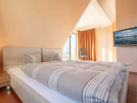 Das erste Schlafzimmer mit Zugang zum großen Balkon