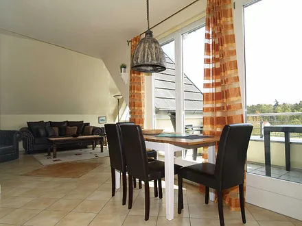 Der Wohnbereich mit Sitzecke, Essecke und Zugang zum möblierten Balkon