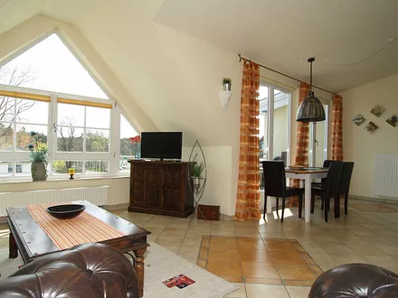 Der Wohnbereich mit Sitzecke, Essecke und Zugang zum möblierten Balkon