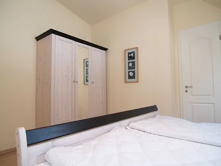 Das Schlafzimmer mit Doppelbett und Kleiderschrank