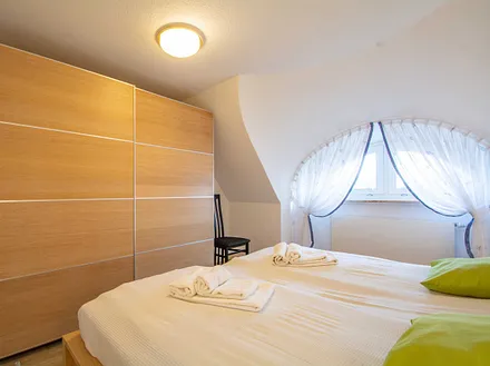 Das erste Schlafzimmer mit Doppelbett und großem Kleiderschrank in der unteren Etage