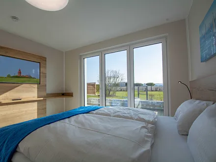 Das erste Schlafzimmer mit Zugang zur großen Südterrasse und Panoramafenstern
