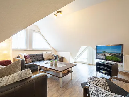 Der gemütliche Wohnbereich mit Couchgarnitur und großem Flachbild-TV