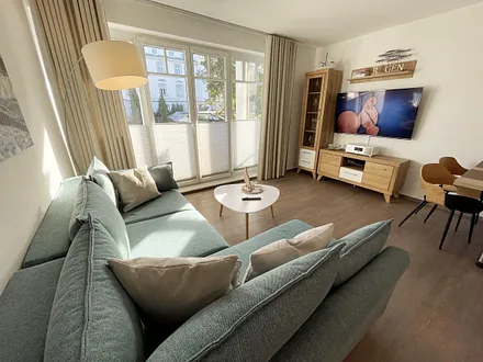 Wohnbereich mit Schlafcouch (Aufbettung für 2 Personen, 1,30 m x 2,00 m), Couchtisch, TV-Board, Smart-LED-TV, Blu-Ray-Player, Mini-Stereo-Anlage mit Bluetooth und USB-Anschluss inkl. Internet-Radio 