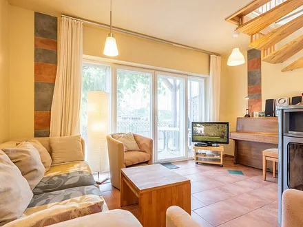 Wohnzimmer mit Kamin und angrenzende Terrasse