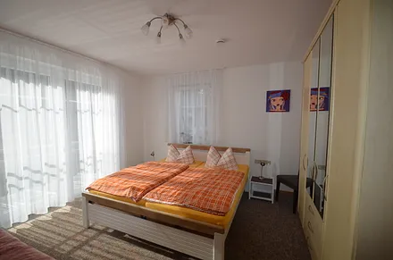 Schlafzimmer mit großem Doppelbett und 1 Einzellbett, Fenster alle mit Rolladen