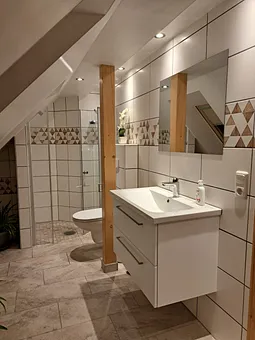 Bad mit Dusche im Hintergrund 