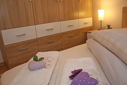 Schlafzimmer mit Doppelbett (1,80 m x 2,00 m), Nachttischkonsolen, großem Kleiderschrank und Insektenschutz