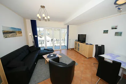 Wohnbereich mit gemütlicher Ledereckcouch (Aufbettung für 3. Person 1,10 m x 1,90 m), Sessel, Tisch, Sideboard, Smart-TV, DAB-Radio und Leselampe