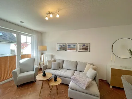 Wohnbereich mit moderner Couch mit Ottomane (1,40 m x 2,00 m), Flachbild-TV, DAB–Radio, DVD-Player, Sessel und Stehlampe