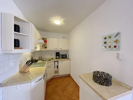 offene Küchenzeile mit Cerankochfeld,Backofen mit Dunstabzugshaube, Geschirrspülmaschine, Mikrowelle, Kühlschrank mit Gefrierfach, Wasserkocher, Toaster, Kaffeemaschine und anderen praktischen Helfern