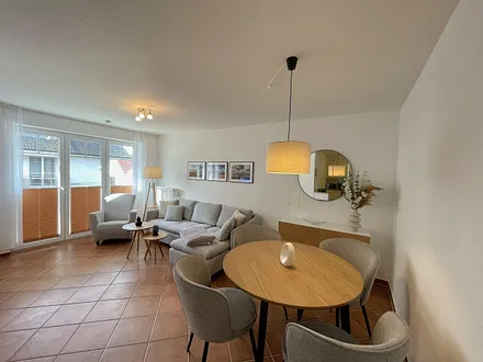 Wohnbereich mit moderner Couch mit Ottomane (1,40 m x 2,00 m), Flachbild-TV, DAB–Radio, DVD-Player, Sessel und Stehlampe