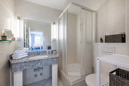 Das Badezimmer hat einen großen Waschtisch, Fön, Kosmetikspiegel  ...