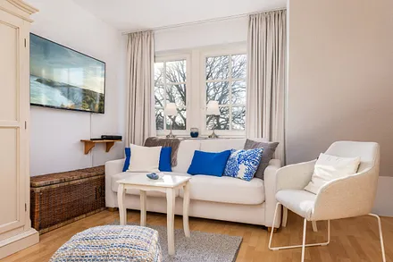 Auf dem großen internetfähigen TV können Sie NETFLIX schauen. Das Fenster hinter der Couch hat Verdunkelungsgardinen.