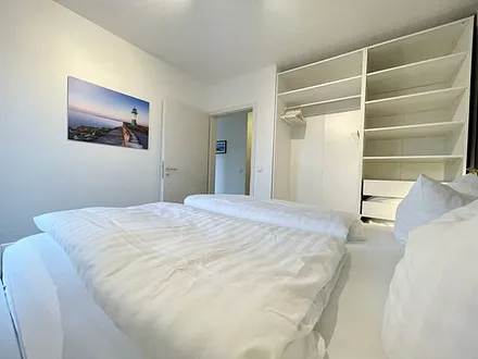 Schlafzimmer mit Doppelbett (1,80 m x 2,00 m), Wand-Nachttischlampen, verstellbare Lattenroste, Insektenschutzgitter sowie geräumiger und offener Kleiderschrank