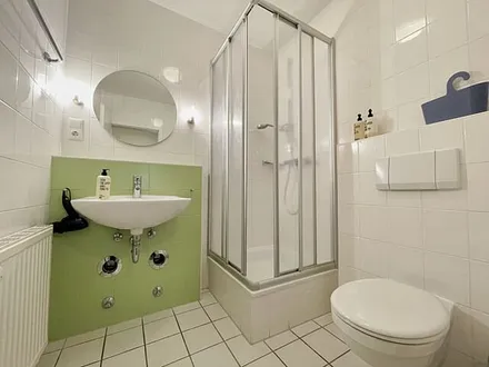 innenliegendes Badezimmer mit Eck-Dusche, Fön, WC, Ablage, beleuchteter Spiegel, Insektenschutzgitter und ein Waschplatz