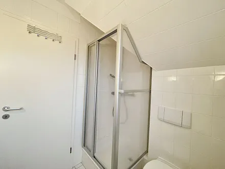 Tageslicht-Badezimmer mit Eck-Dusche, Fön, WC, Ablage, beleuchteter Spiegel, Waschplatz und ein Insektenschutzgitter