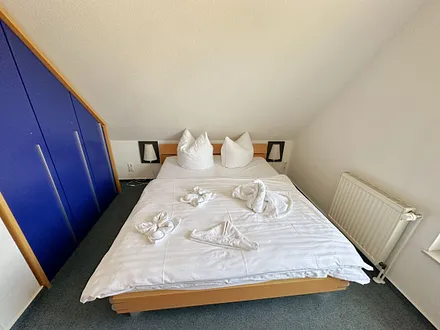 Schlafzimmer mit Doppelbett (1,60 m x 2,00 m), Wand-Nachttischlampe, verstellbare Lattenroste sowie ein geräumiger Kleiderschrank