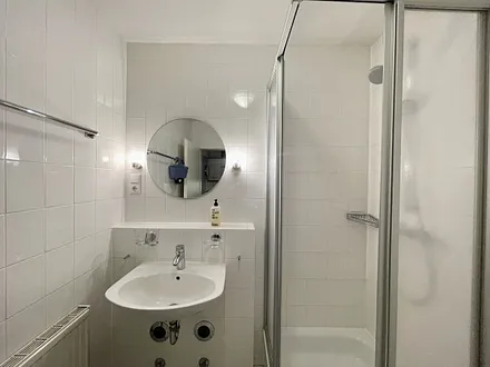 innenliegendes Badezimmer mit Eck-Dusche, Fön, WC, Ablage, beleuchteter Spiegel, Insektenschutzgitter und ein Waschplatz