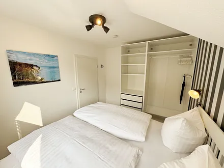 Schlafzimmer mit Doppelbett (1,60 m x 2,00 m), Wand-Nachttischlampe, verstellbare Lattenroste sowie ein geräumiger Kleiderschrank