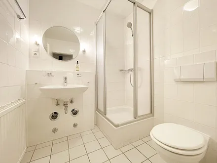 innenliegendes Badezimmer mit Eck-Dusche, Fön, WC, Ablage, beleuchteter Spiegel, Insektenschutzgitter und ein Waschplatz