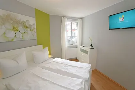 Schlafzimmer mit Doppelbett (1,60 m x 2,00 m), hochwertigen Matratzen, verstellbaren Lattenrosten, 2 Nachttischlampen, Flachbild-TV, Radiowecker und Kleiderschrank