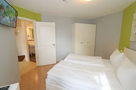 Schlafzimmer mit Doppelbett (1,60 m x 2,00 m), hochwertigen Matratzen, verstellbaren Lattenrosten, 2 Nachttischlampen, Flachbild-TV, Radiowecker und Kleiderschrank