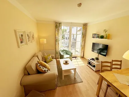 geräumiger Wohnbereich mit Couch (Aufbettungsmöglichkeit für 3. Person – 1,20 m x 1,96 m), Sessel, Couchtisch, Leselampe, Flachbild-TV sowie eine Mini-Stereoanlage mit CD und DVD-Player