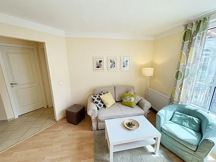 geräumiger Wohnbereich mit Couch (Aufbettungsmöglichkeit für 3. Person – 1,20 m x 1,96 m), Sessel, Couchtisch, Leselampe, Flachbild-TV sowie eine Mini-Stereoanlage mit CD und DVD-Player