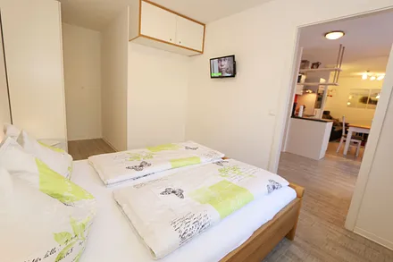 Schlafzimmer mit Doppelbett (1,80 m x 2,00 m), verstellbare Lattenroste, Nachttischkonsolen, Kleiderschrank und einem Flachbild-TV