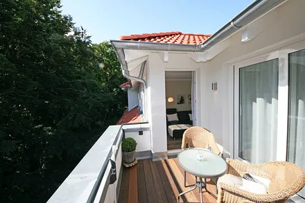 bestuhlte Dachterrasse (West) mit Bangkireiboden, Terrassenmöbel und Blick in die Baumwipfel