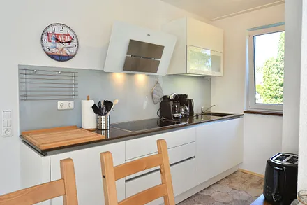 moderne offene Küche mit großem Kühlschrank, Geschirrspüler, Cerankochfeld, Backofen