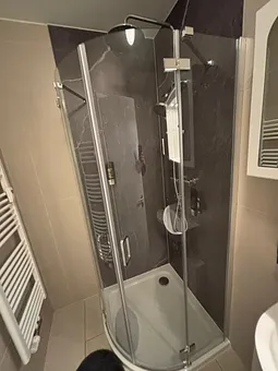 Blick in das Bad mit Regendusche,WC, Fön 