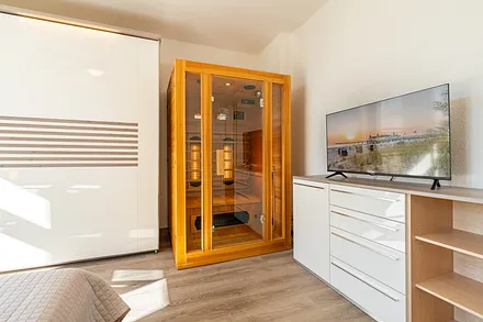 1. Schlafzimmer mit Doppelbett, Zugang zum Balkon und Infrarotsauna