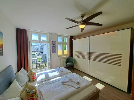 1. Schlafzimmer mit Doppelbett, TV, großem Kleiderschrank, Infrarotsaunakabine und Zugang zum Balkon