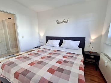 Schlafzimmer mit Doppelbett und geräumigem Kleiderschrank