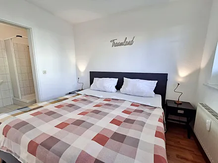 Schlafzimmer mit Doppelbett und geräumigem Kleiderschrank