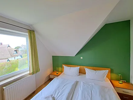 Schlafzimmer mit Doppelbett und Kleiderschrank