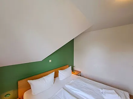 Schlafzimmer mit Doppelbett und Kleiderschrank