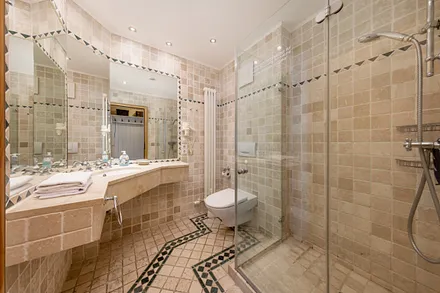 Das schöne Bad mit Eckwaschtisch, Dusche, WC und Fön.