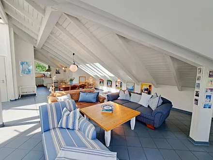 großzügiger Wohn- und Essbereich mit Leseecke, Kamin, Esstisch und offener Küche