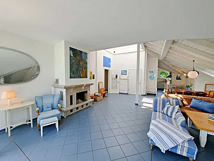 großzügiger Wohn- und Essbereich mit Leseecke, Kamin, Esstisch und offener Küche