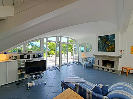 großzügiger Wohn- und Essbereich mit Leseecke, Kamin, Esstisch und offener Küche