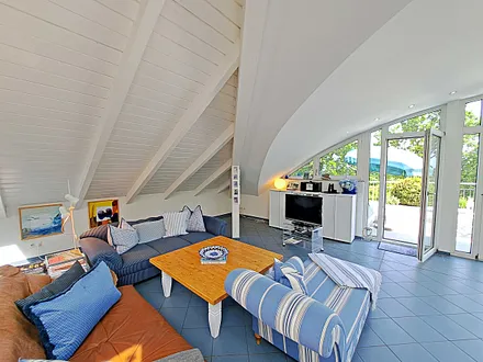 großzügiger Wohn- und Essbereich mit Leseecke, Kamin, Esstisch und offener Küche