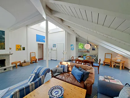 großzügiger Wohn- und Essbereich mit Leseecke, Kamin, Esstisch und offener Küche