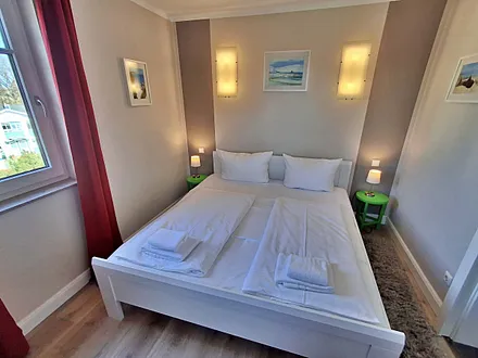 Schlafzimmer mit Doppelbett und zweitem Flachbild-TV