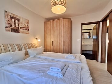 Schlafzimmer mit Doppelbett, Kleiderschrank und zusätzlichem TV